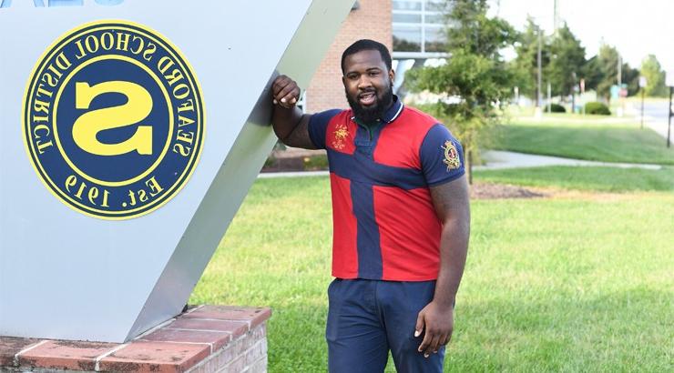 Juwan Mullen standing in front of the Seaford High School sign